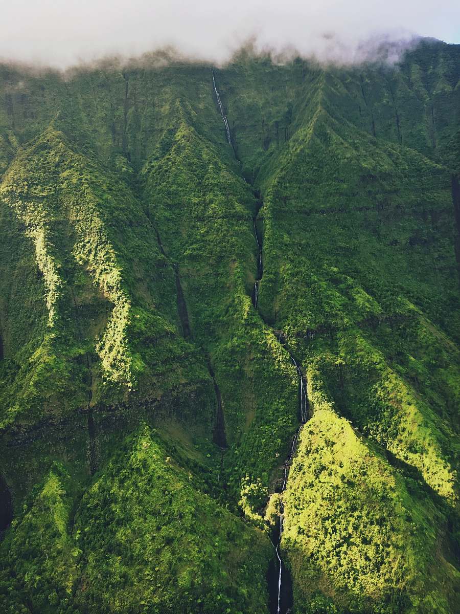 hawaii green mountain under white clouds mountain side